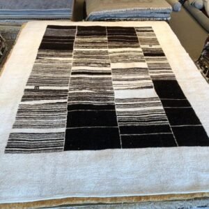 Eco-friendly 9x12 handmade hemp area rug with wide ivory border and irregular black and ivory stripes, sustainable minimalist design for modern interiors.