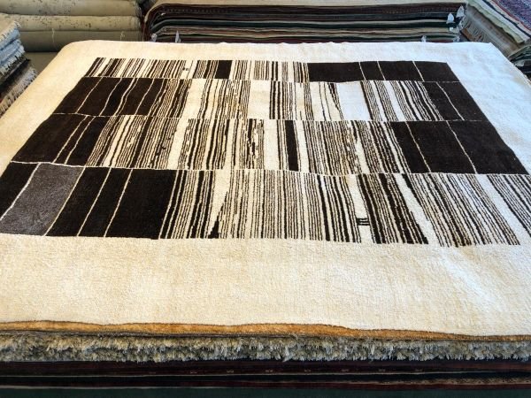 Eco-friendly 9x12 handmade hemp area rug with wide ivory border and irregular black and ivory stripes, sustainable minimalist design for modern interiors.