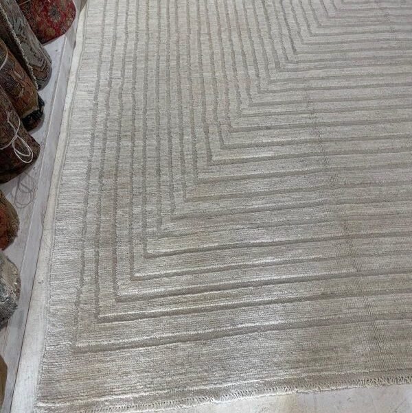 Minimalist ivory rug with textured concentric pattern, contemporary handmade design