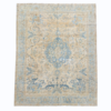 An elegant antique Persian Tabriz rug featuring a traditional central medallion surrounded by delicate floral motifs. Its ivory, beige, and blue palette has been beautifully softened with an antique wash.