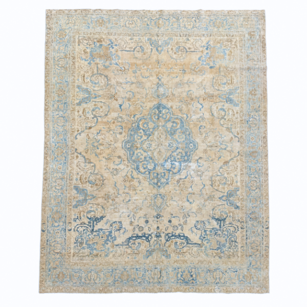 An elegant antique Persian Tabriz rug featuring a traditional central medallion surrounded by delicate floral motifs. Its ivory, beige, and blue palette has been beautifully softened with an antique wash.